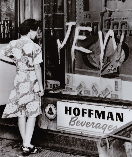 Woman viewing defaced storefront